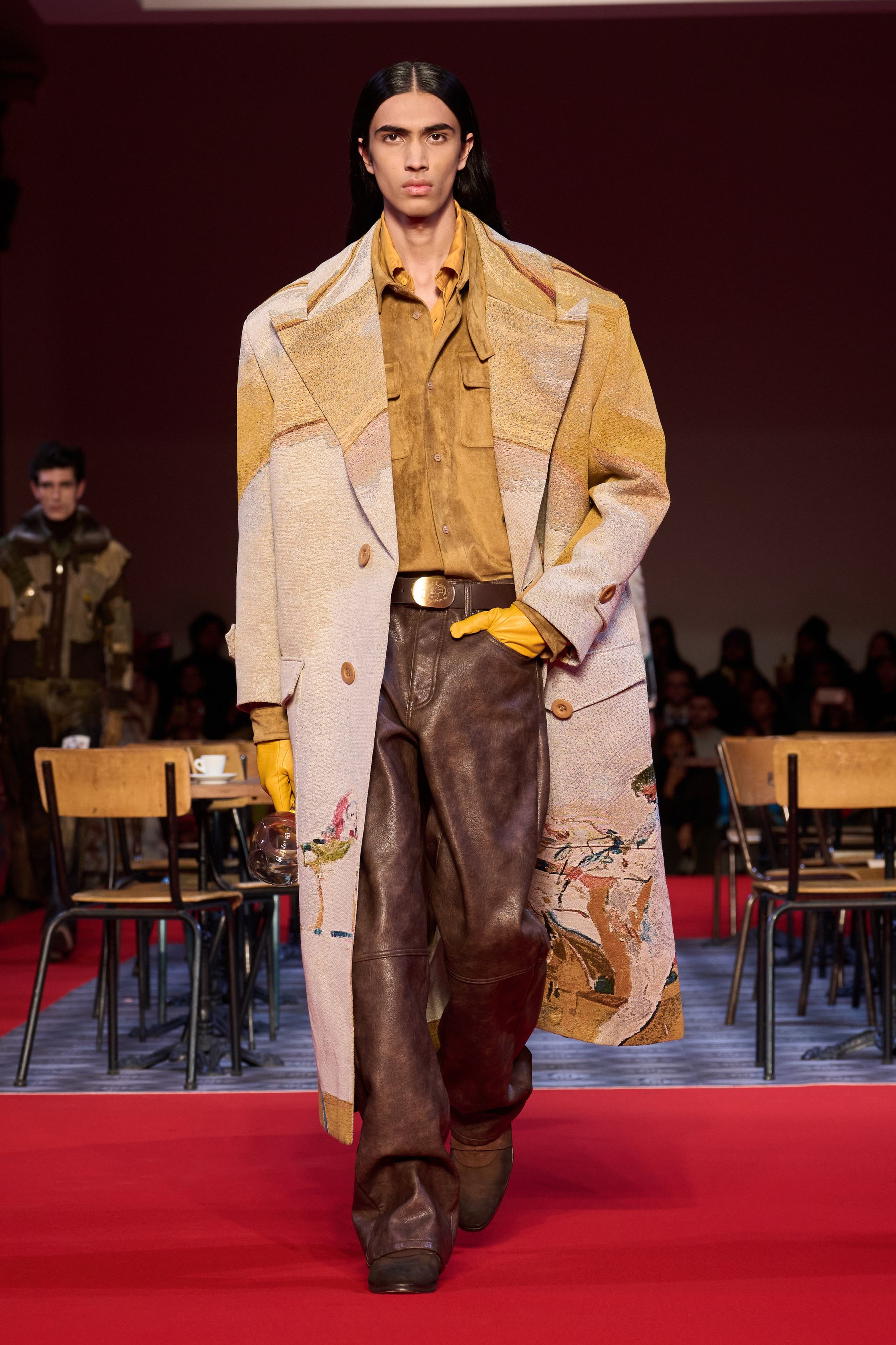KidSuper 26FW 再次用“情绪拼贴”对抗工业化时尚秩序。手绘印花、夸张比例与情绪化色彩在红毯式秀场中被推向极致，服装不追求修饰身体，而是作为情感与记忆的载体存在。粗犷皮革、绘画感大衣与幼稚却真诚的图案语言并置，构成一种反精英、反理性的当代浪漫主义。KidSuper 依旧不完美，却极其真实-顽石频道趋势研究